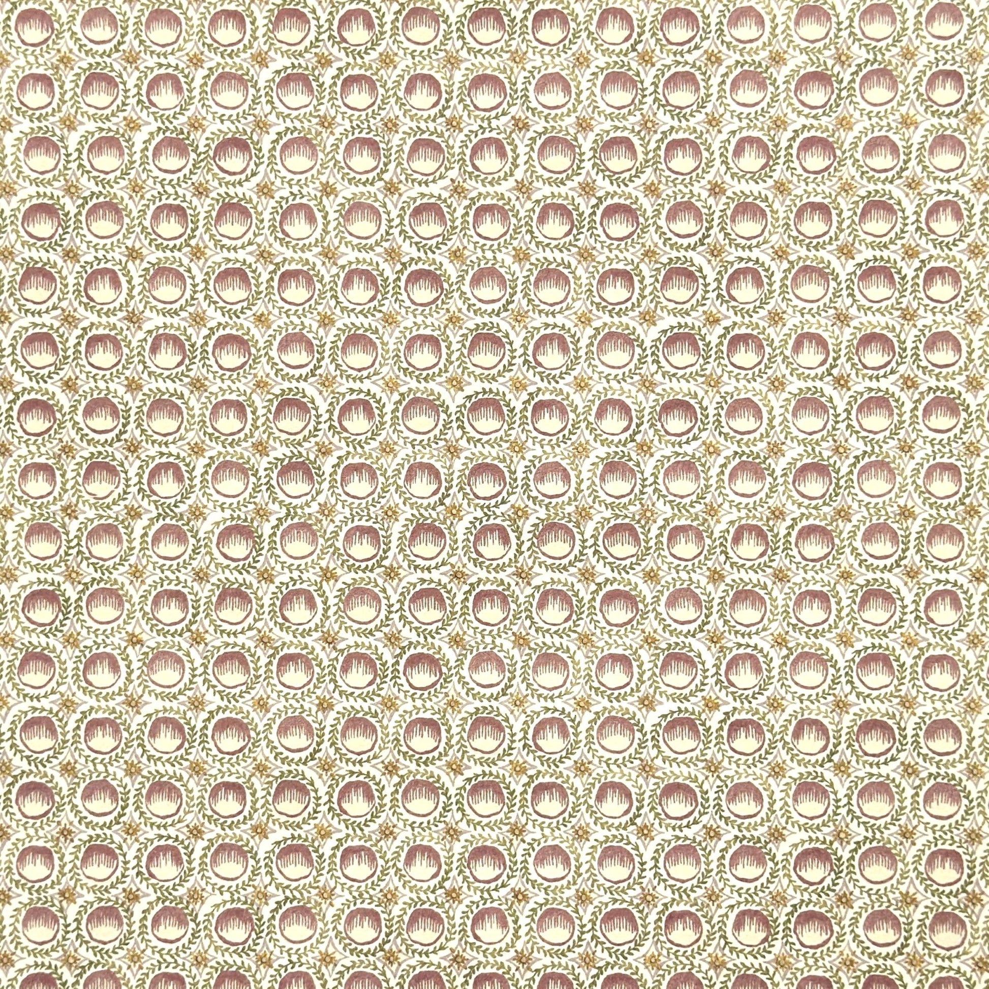 close up of a sheet of wrapping paper with a block printed design of rows of English steam puddings in pink
