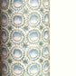 A close-up of a patterned wrapping paper featuring a repeating botanical design with blue block printed steam puddings, green leafy wreaths, and small yellow accents on a white background.