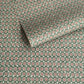 A sheet patterned wrapping paper with a repeating floral medallion design in muted green, dusty pink, and cream by The Kensington Paperie brand