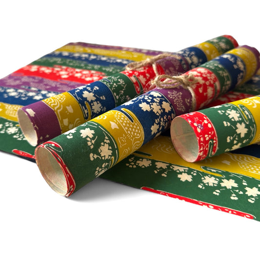 vintage katazome-shi stencil-dyed small papers from Japan. Stripes in green, yellow, blue, purple and red with cream Japanese motifs. Pictured rolled.