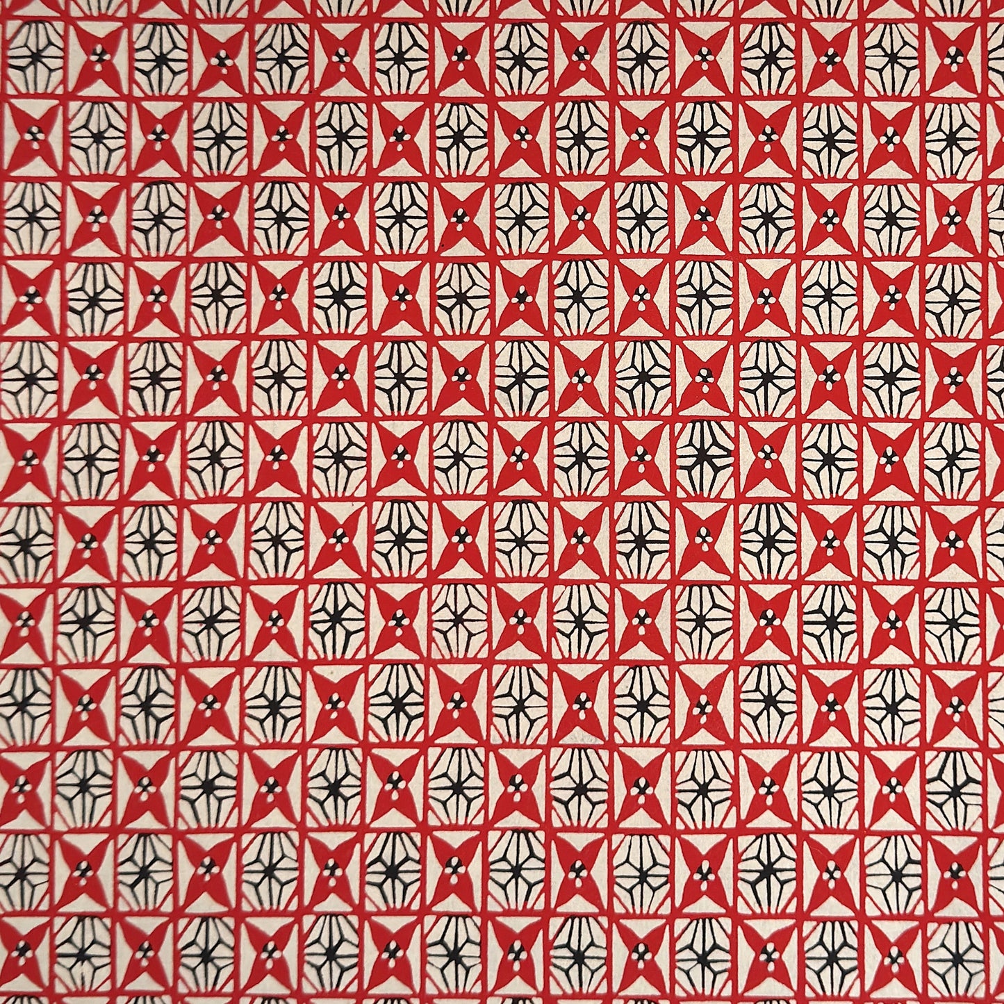 vintage katazome stencil dyed paper. Red and black star pattern on cream paper. 