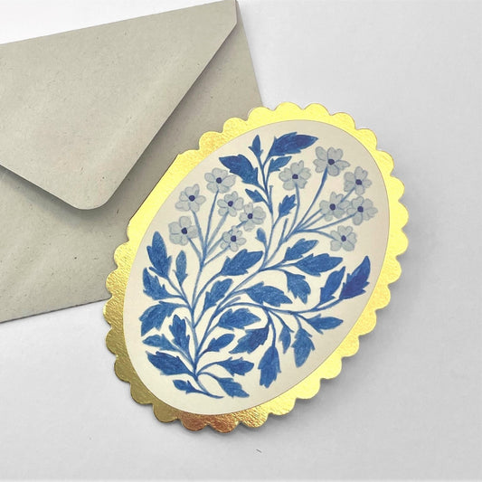 oval greetings card with a blue floral design and a gold foiled scalloped edge. By Wanderlust. Pictured with envelope