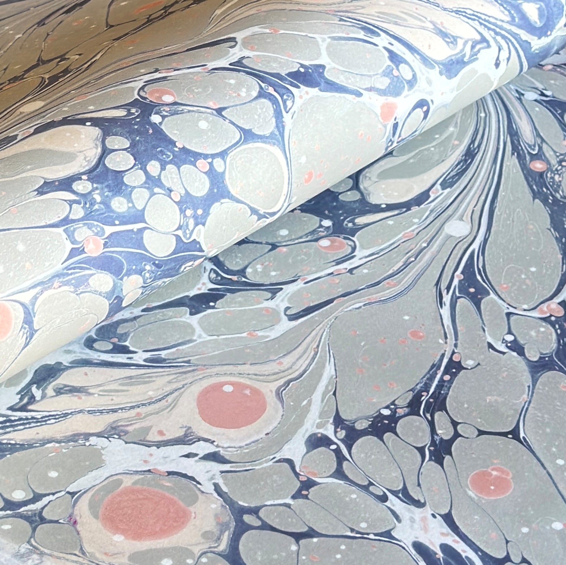 Printed marbled wrapping paper in dusty blue, grey and pink. 