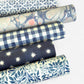 patterned paper / gift wrap with a blue and white tile design. By Wanderlust.  Rolled alongside other patterns