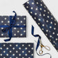 chequered navy blue with cream stars patterned wrapping paper. Pictured wrapped 