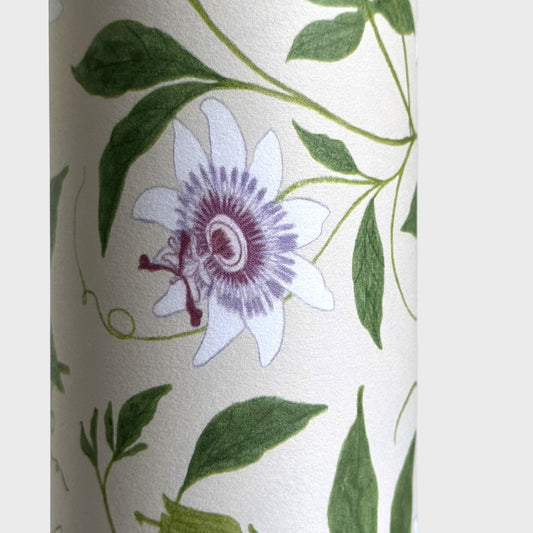floral wrapping paper with pink passion flowers, green leaves on a cream background. Close up  