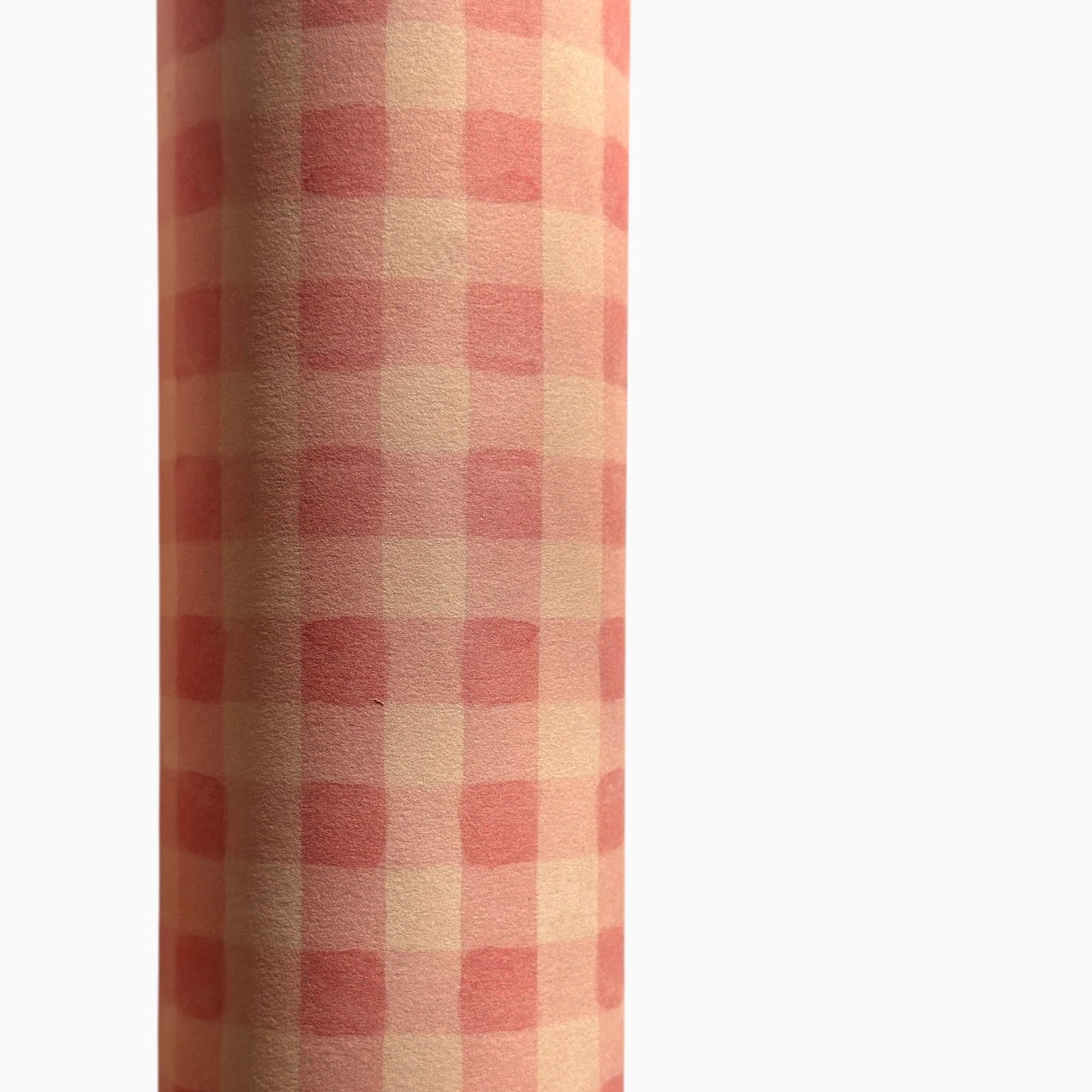 Checkered pattern wrapping paper with pink and beige squares. Close up