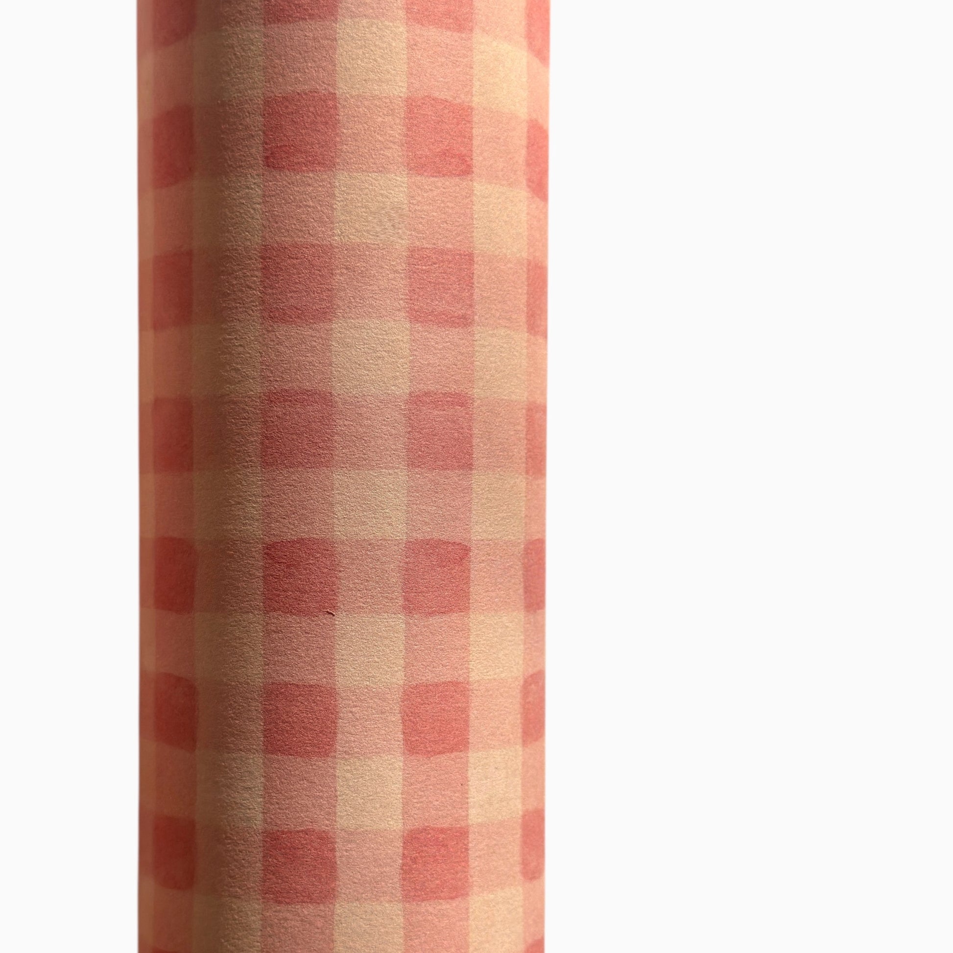 Checkered pattern wrapping paper with pink and beige squares. Close up