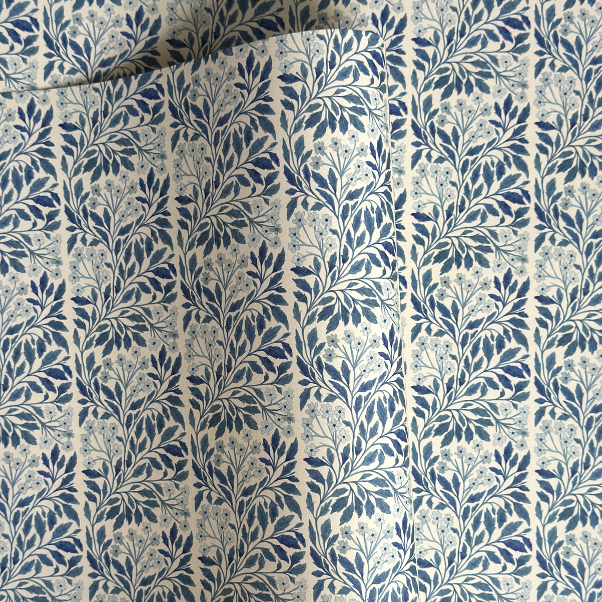 patterned paper / gift wrap with a delicate floral repeat pattern in blue on a ivory background.  By Wanderlust