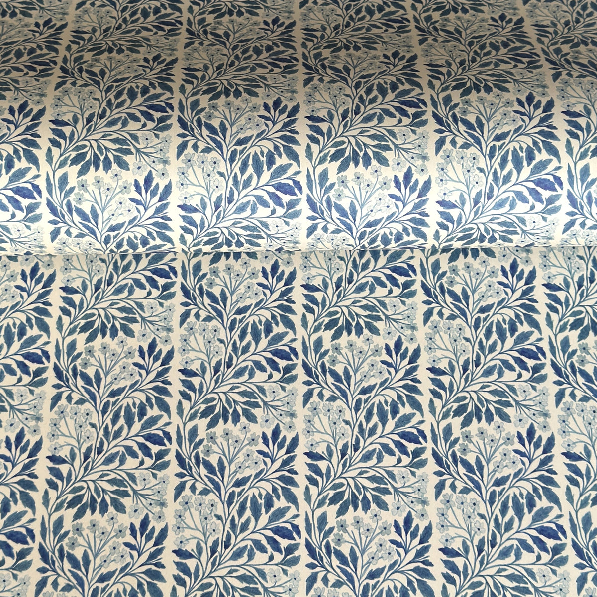 patterned paper / gift wrap with a delicate floral repeat pattern in blue on a ivory background.  By Wanderlust