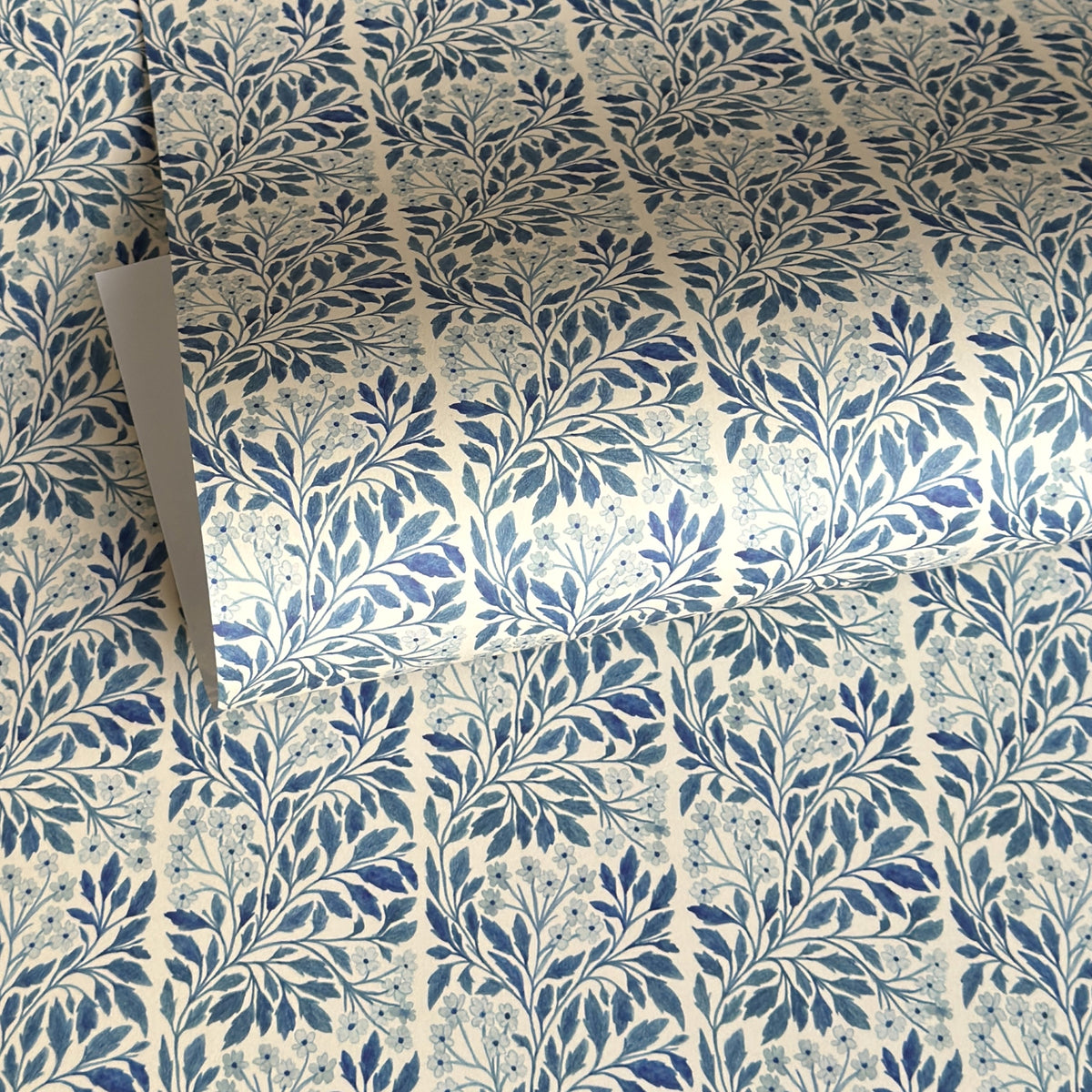 patterned paper / gift wrap with a delicate floral repeat pattern in blue on a ivory background.  By Wanderlust
