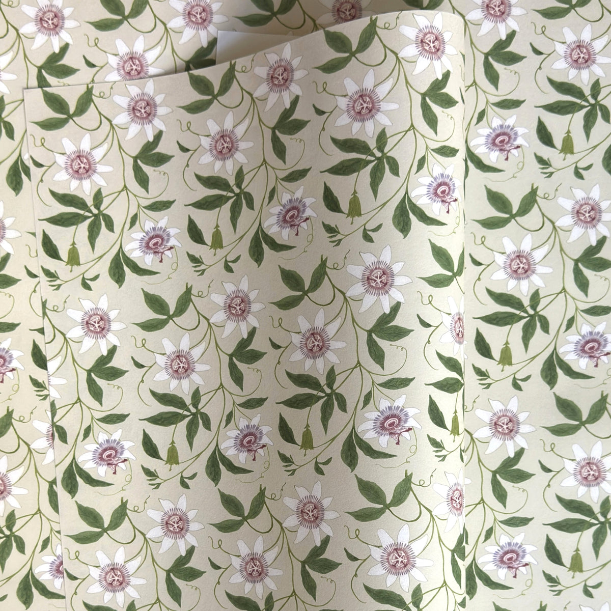floral wrapping paper with pink passion flowers, green leaves on a cream background  