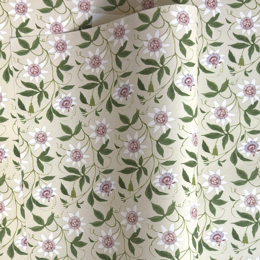 floral wrapping paper with pink passion flowers, green leaves on a cream background  