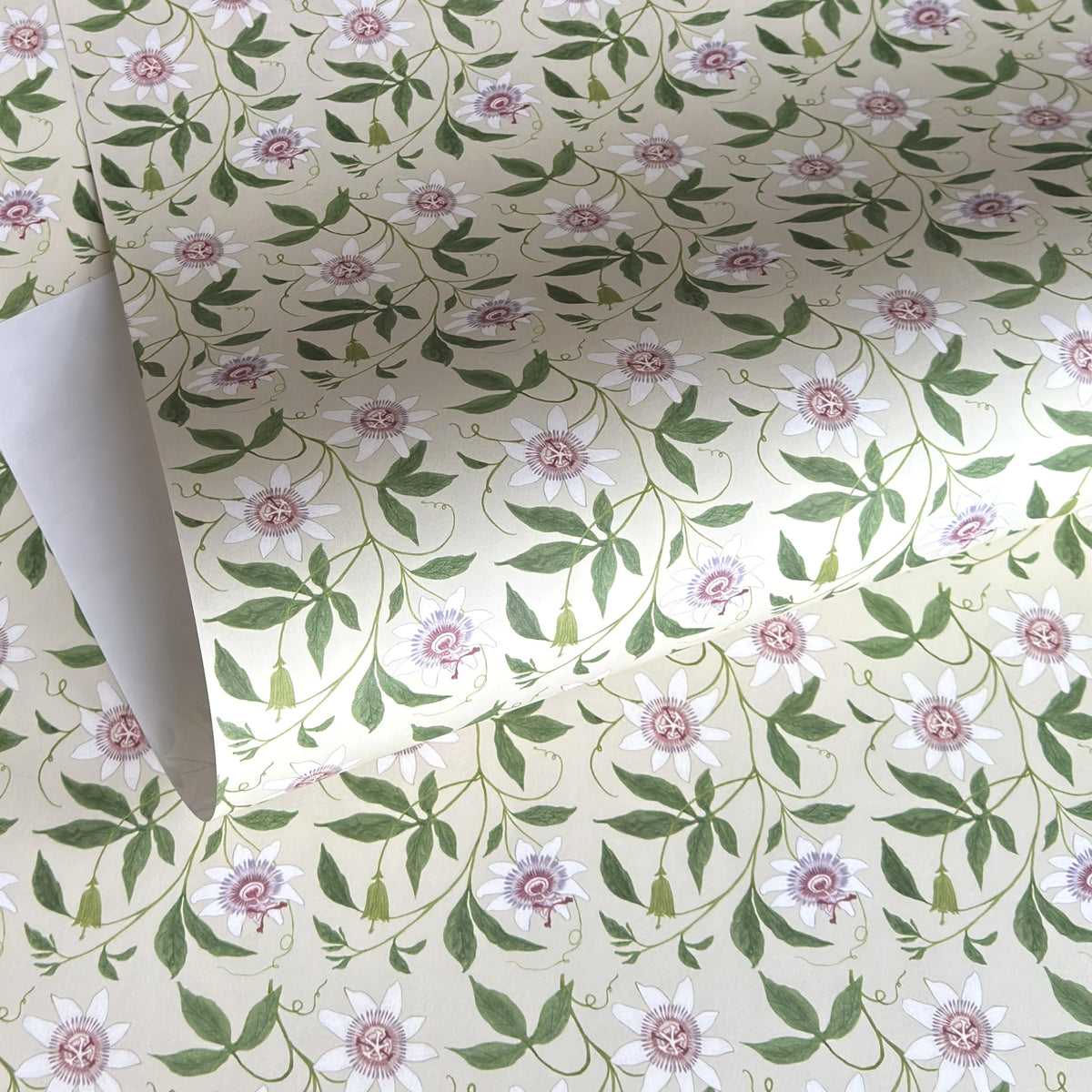 floral wrapping paper with pink passion flowers, green leaves on a cream background  