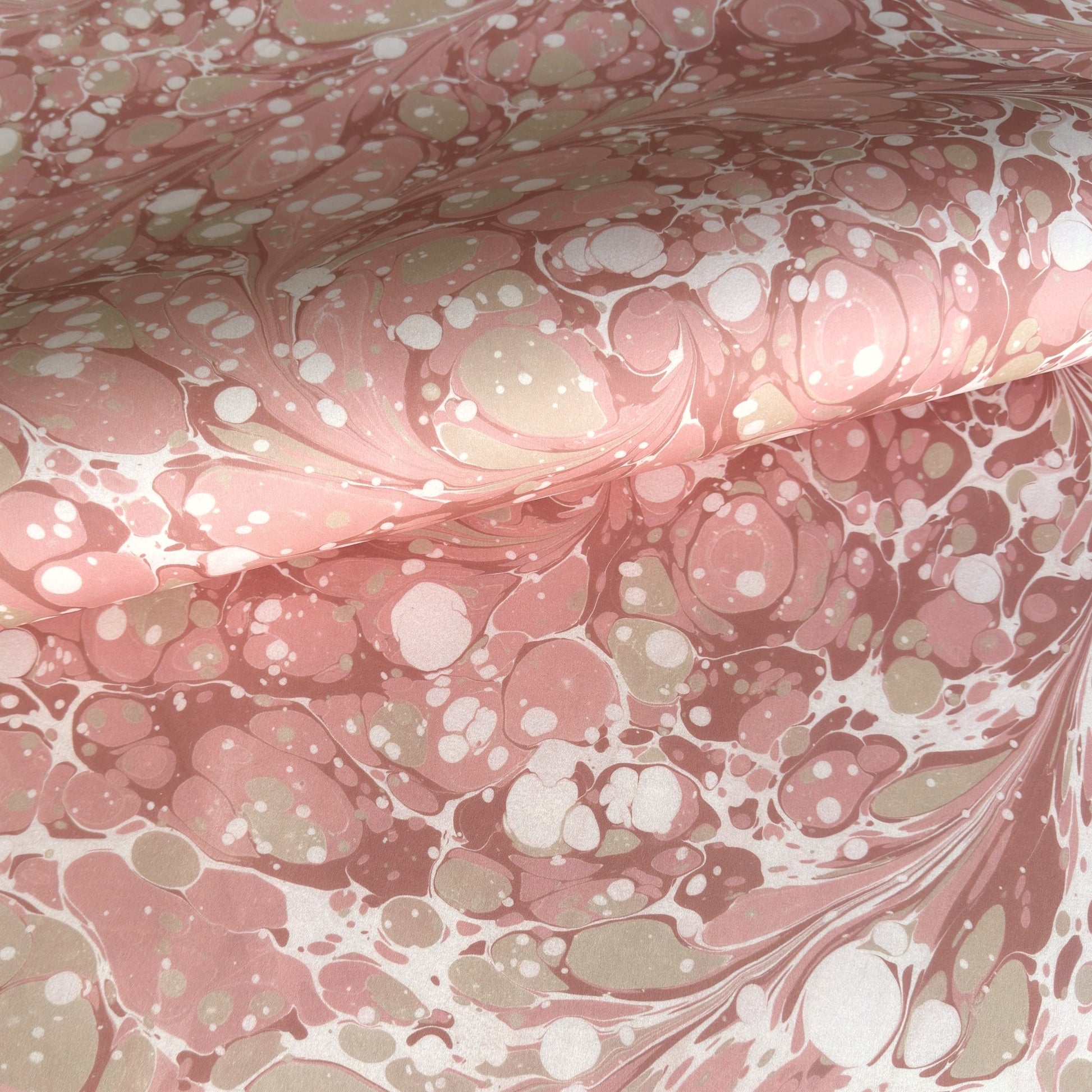 Printed marbled wrapping paper in dusty pink, taupe and white. 