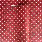 Red wrapping paper by Wanderlust with a white star pattern, shown folded to display its texture and design.