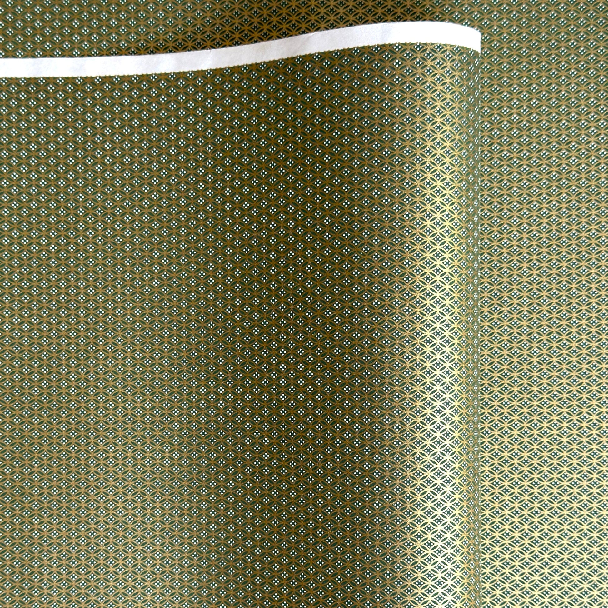 a sheet of Japanese silkscreen printed chiyogami paper with a mini geometric design in gold on green backdrop 
