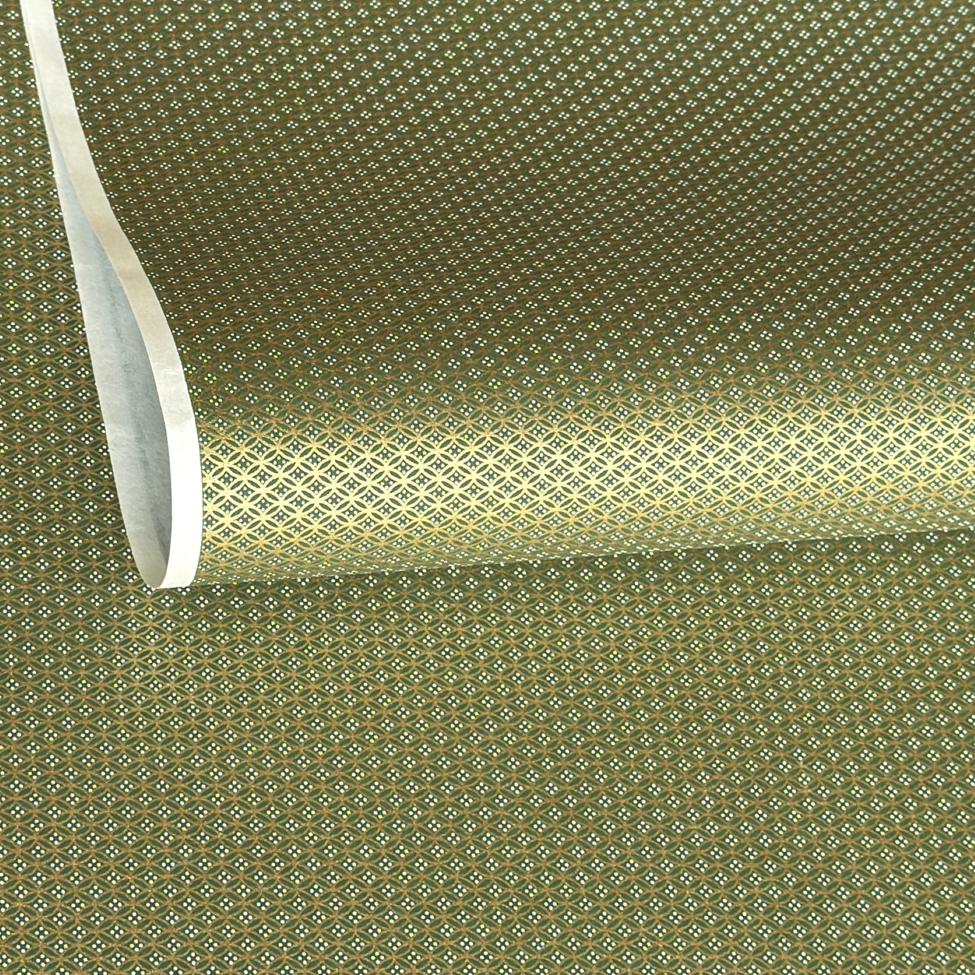 a sheet of Japanese silkscreen printed chiyogami paper with a mini geometric design in gold on green backdrop 