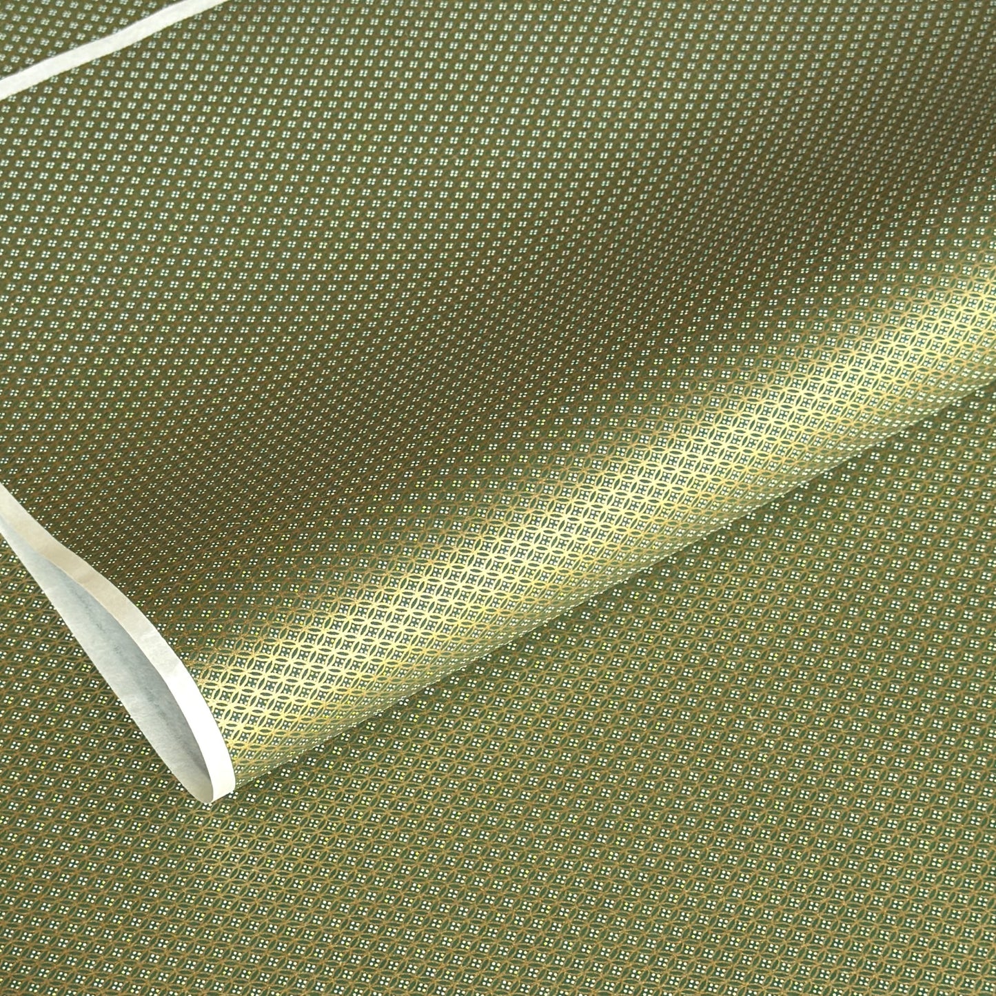 a sheet of Japanese silkscreen printed chiyogami paper with a mini geometric design in gold on green backdrop 
