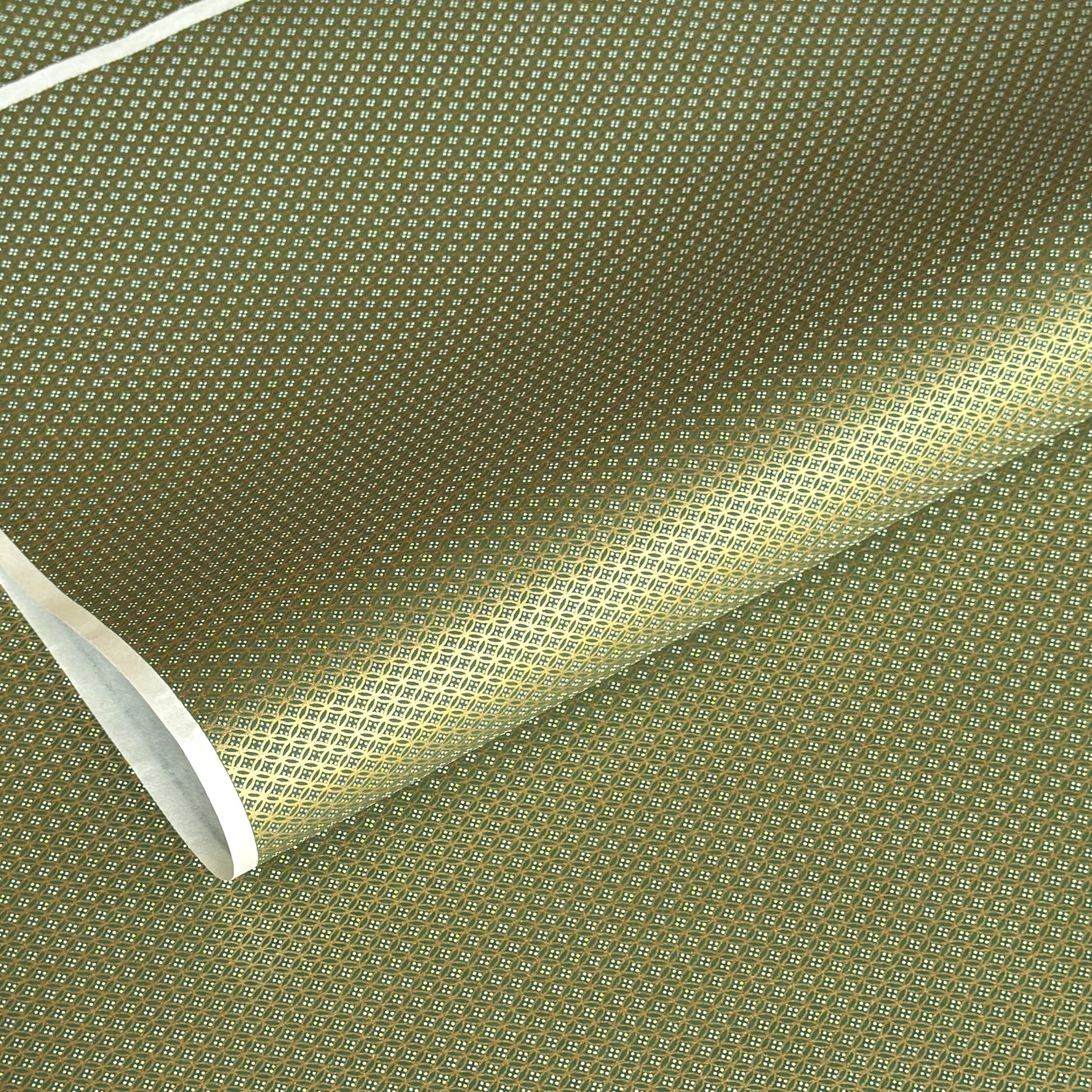 a sheet of Japanese silkscreen printed chiyogami paper with a mini geometric design in gold on green backdrop 