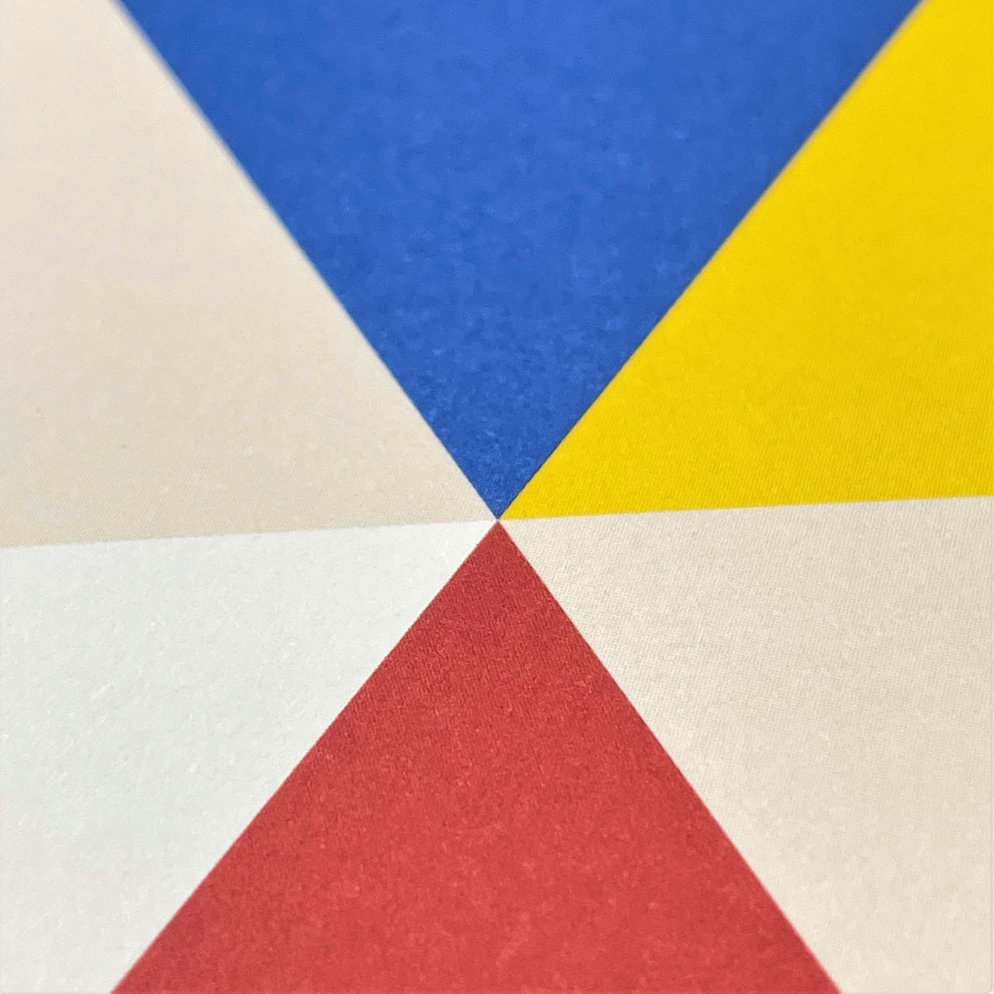 Greeting card with colourful abstract triangles, close up of card