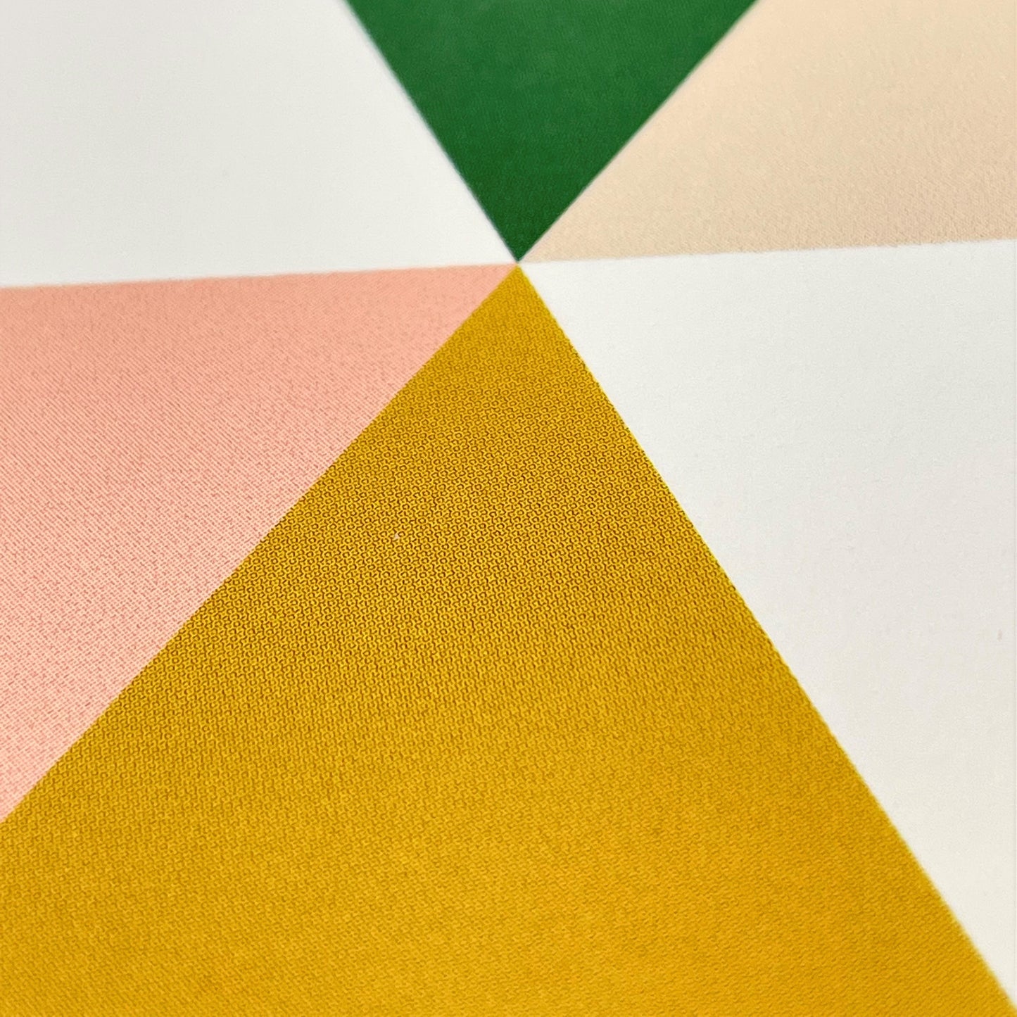 Greeting card with green, mustard, pink abstract triangles, close up of card