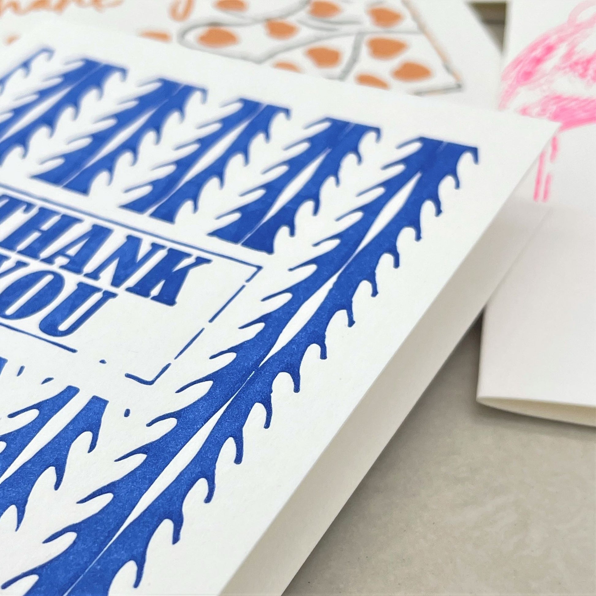 small greetings card with thank you message in blue and geometric pattern, close up of the card