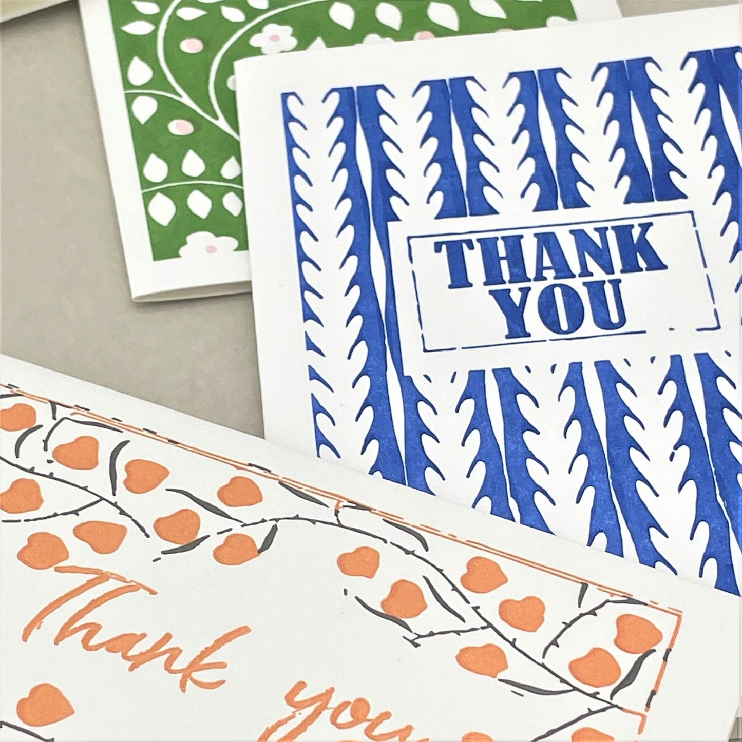 small greetings card, orange leaves and thank you messages, shown alongside a blue thank you card