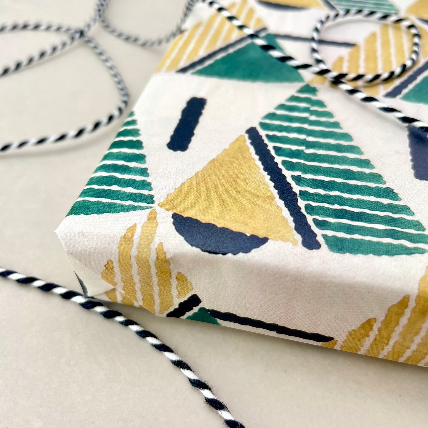 wrapping paper with yellow and green triangular geometry repeat design, wrapped present, detail