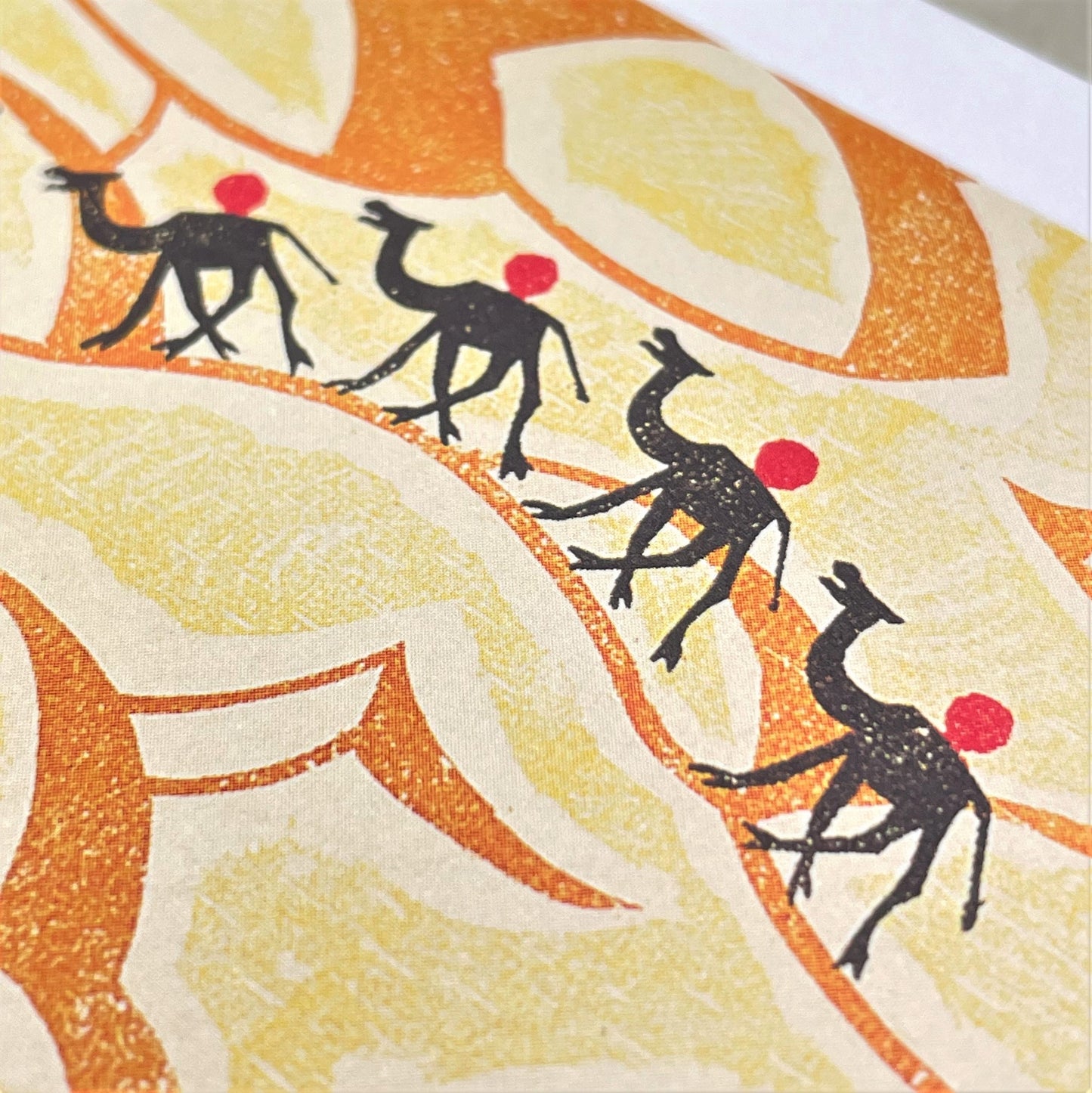 greetings card showing a stylised drawing of four camels in the desert, close up of the card