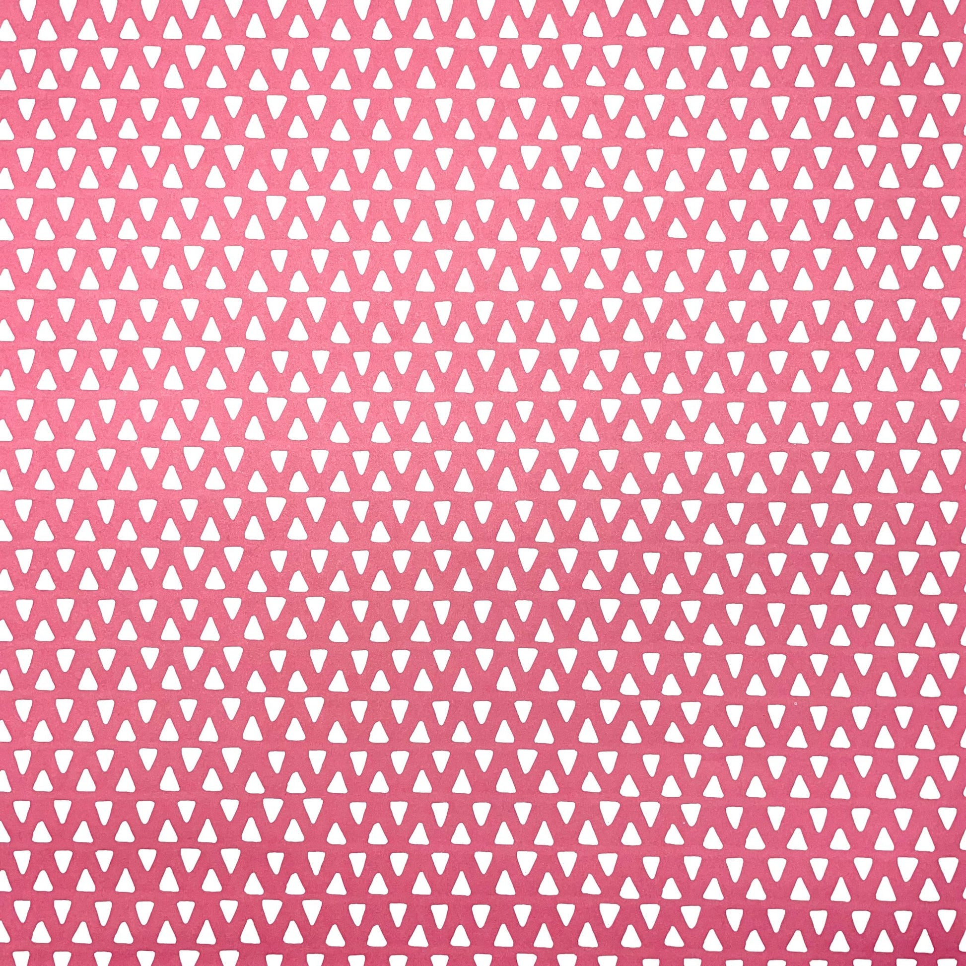 wrapping paper with pink background and repeat pattern of little white triangles by Heather Evelyn