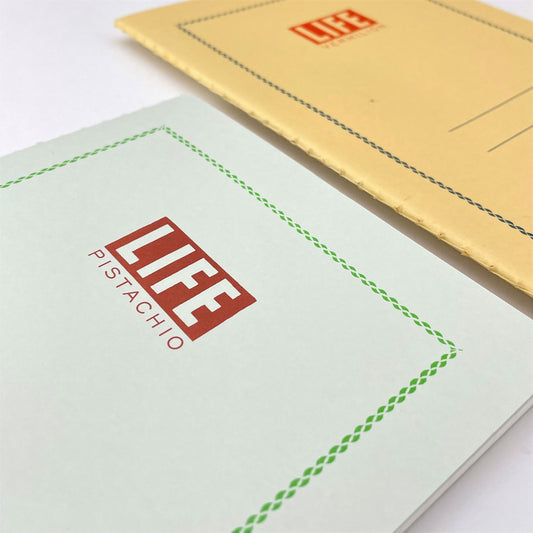 A5 softcover notebook with a soft green cover with green border and branding, close-up