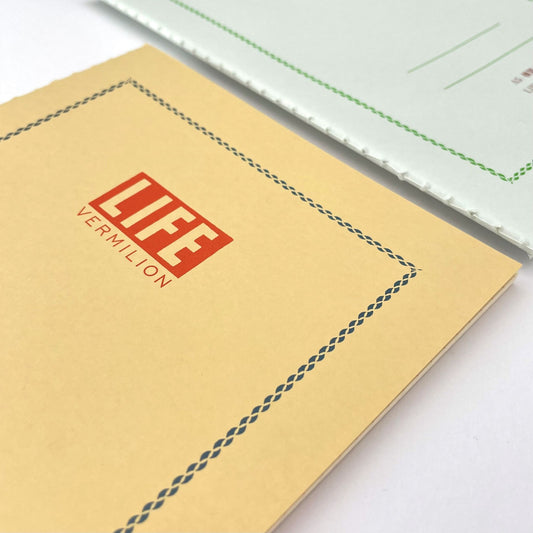 A5 softcover notebook with a soft yellow cover with blue border and branding, close-up