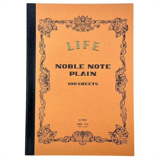 Softcover notebook with plain pages. The cover is plain ochre with a decorative black border and branding. Life Noble range by Japanese brand Life