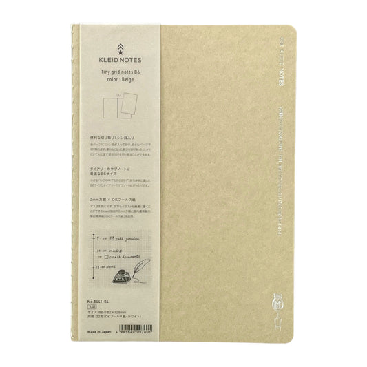 Soft cover notebook with grid format pages.  Cover is plain beige with branded belly band