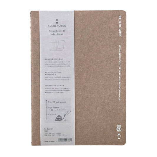 Soft cover notebook with grid format pages. Cover is plain brown with branded belly band