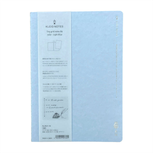 Soft cover notebook with grid format pages. Cover is plain light blue with branded belly band
