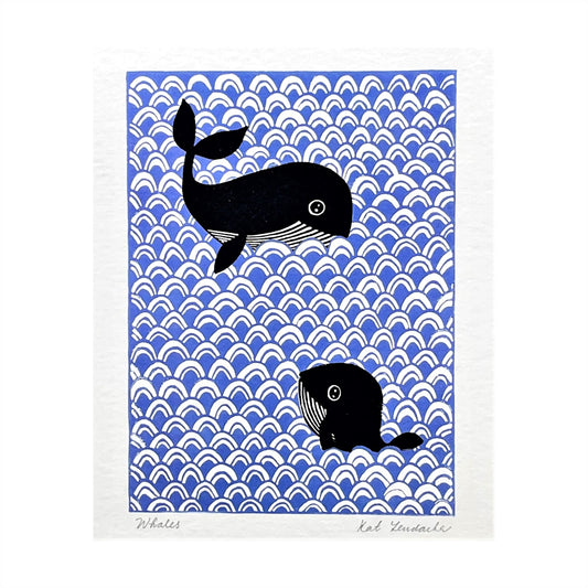 greetings card showing two black and white whales swimming against a blue backdrop of japanese wave design