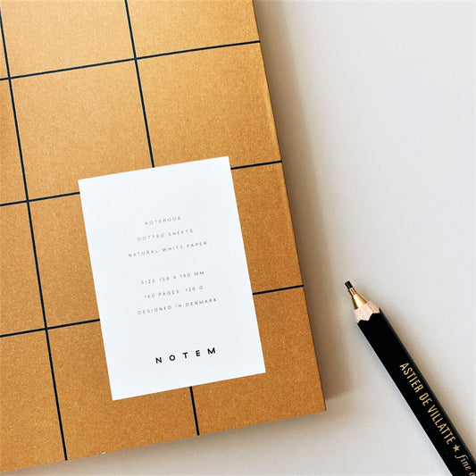 Layflat notebook with dark ochre softcover with black grid lines, close-up