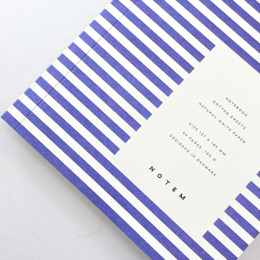 Pocket size notebook with a narrow bright blue and white stripe softcover., close-up