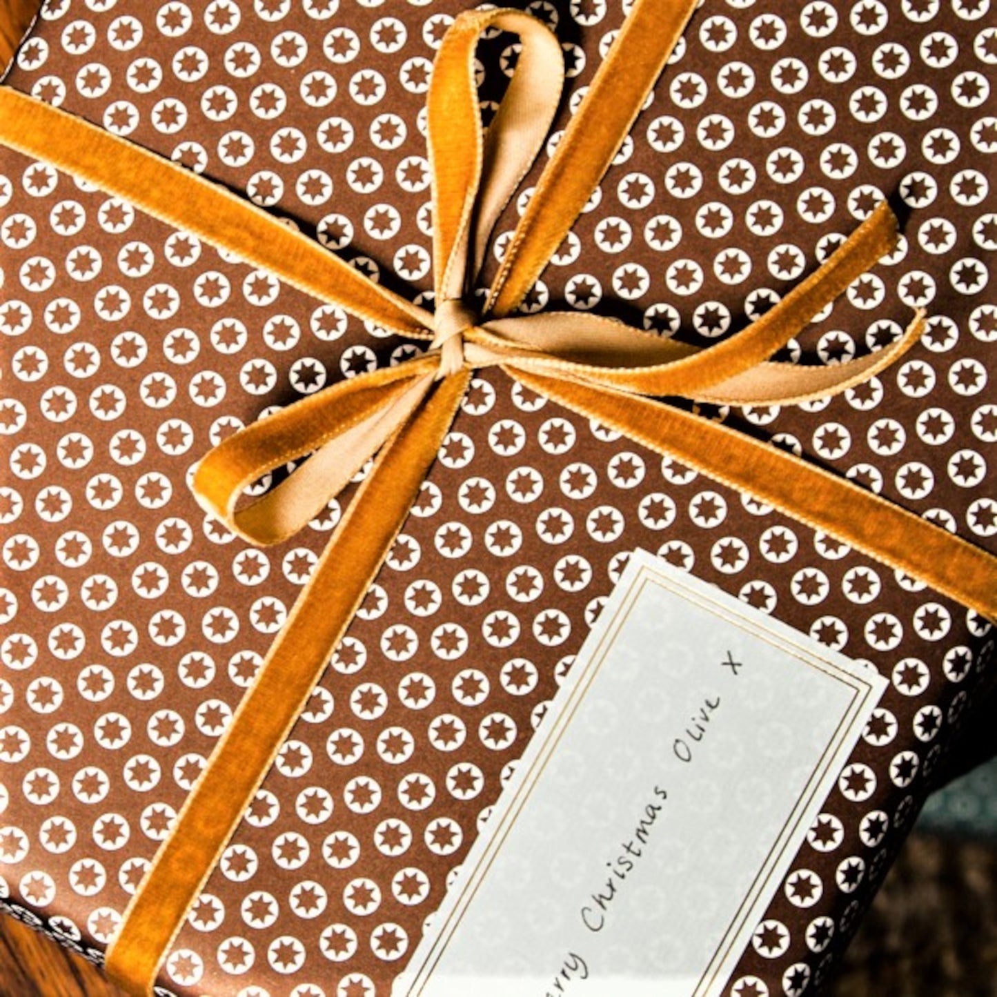 Pack of 10 self-adhesive white labels with double lined gold brass foiled border, pictured as a gift label on a present