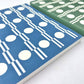 A5 softback notebook with geometric blue and white circle repeat patterned cover. Plain inner pages, Close-up
