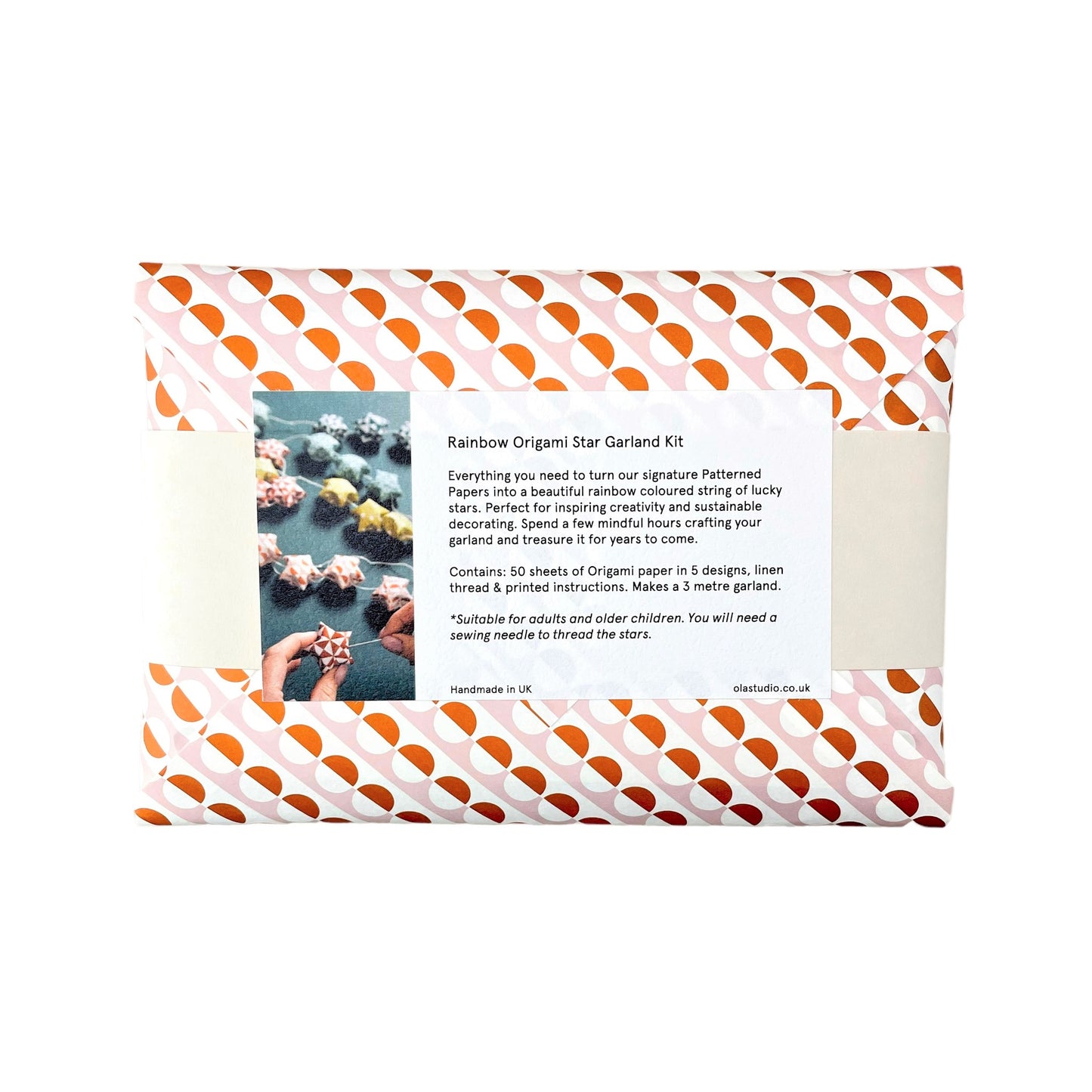 A garland of small paper origami patterned stars "lucky stars" , pictured is the reverse of the outer pink and orange envelope packaging with contents