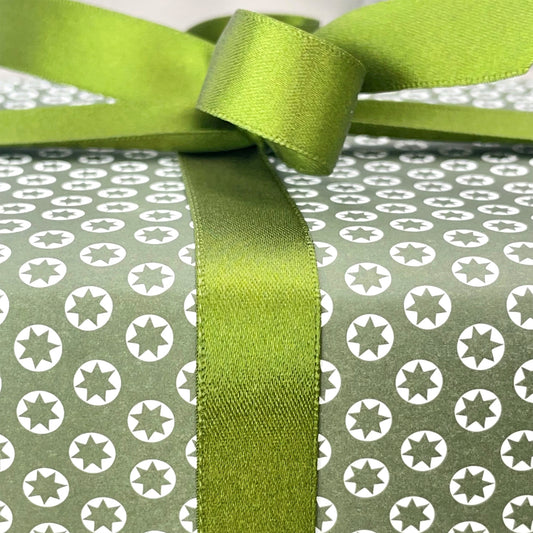 wrapping paper with an abstract tiny stars pattern in olive and white, close-up