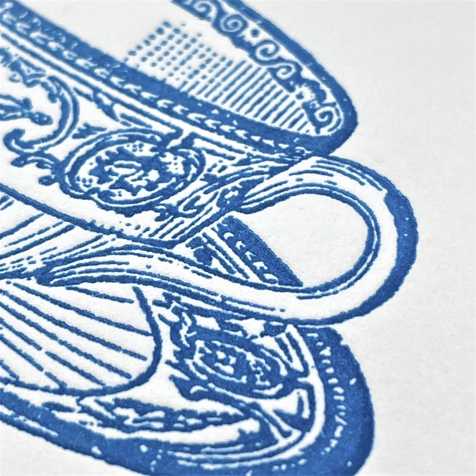 letterpress greetings card of a drawing of a wedgewood teacup and saucer, blue ink on white, close-up